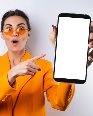 young-woman-trendy-stylish-glasses-bright-orange-oversized-jacket-white-background-holds-phone-with-blank-white-screen 1